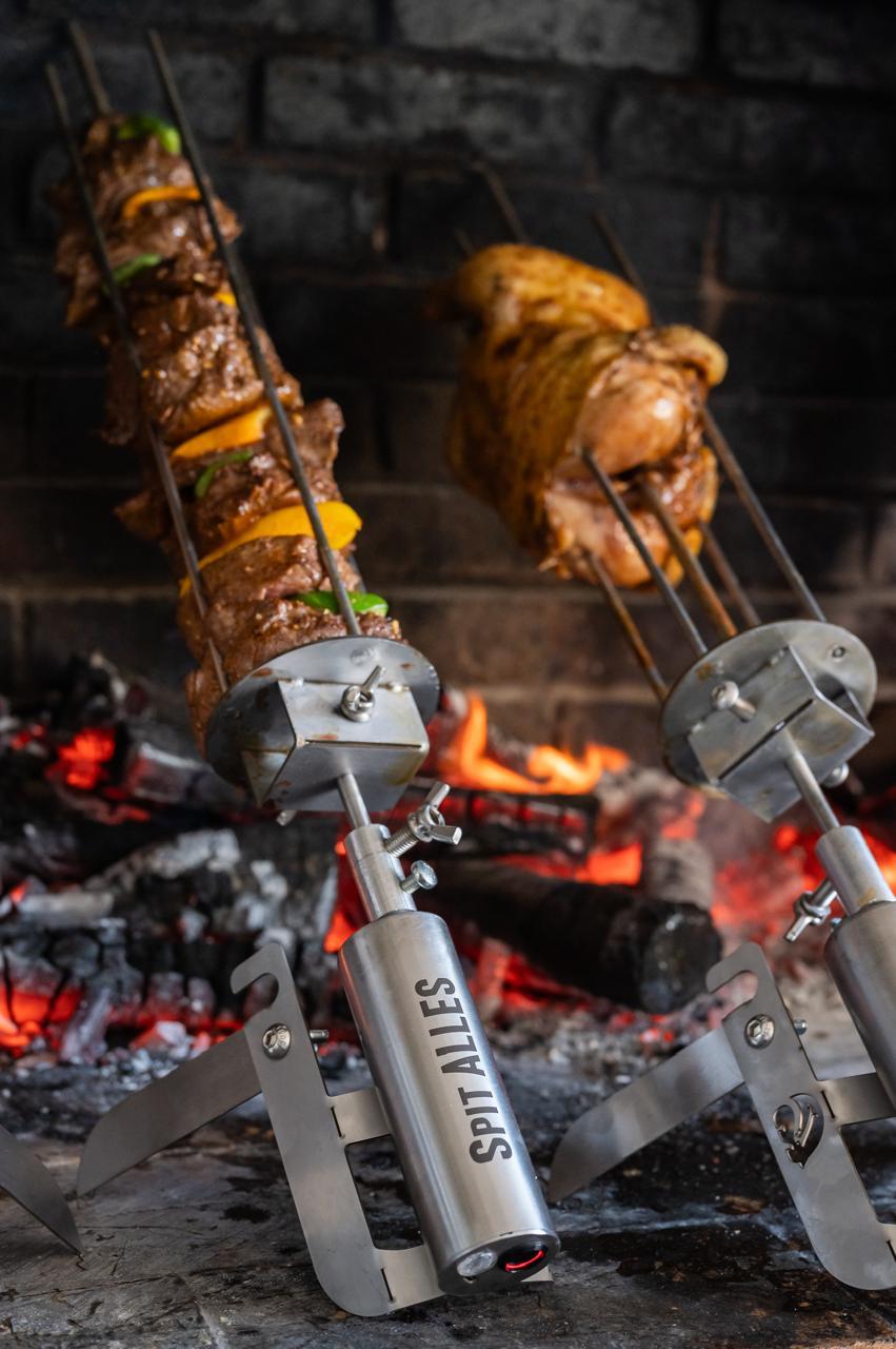 Kebab skewers turning over hot coals on two SpitAlles stands