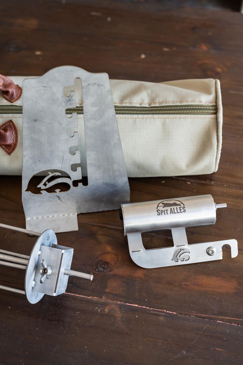 The SpitAlles counter stand leaning against the branded canvas bag on a wooden table